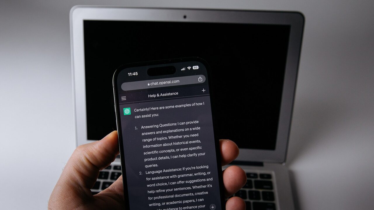Smartphone com aplicativo de inteligência artificial aberto, ao lado de um notebook