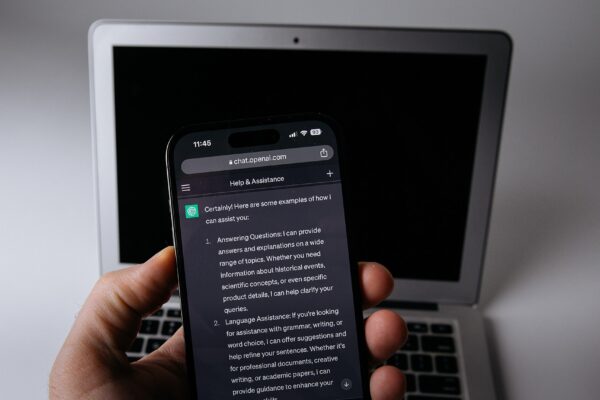 Smartphone com aplicativo de inteligência artificial aberto, ao lado de um notebook